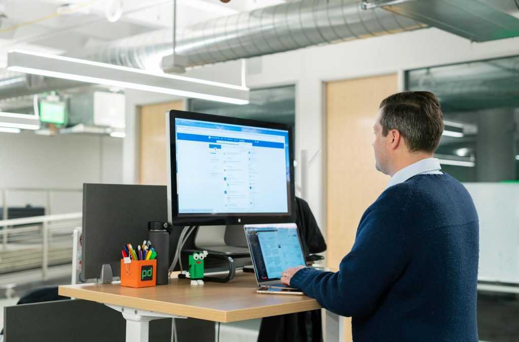 Man working at a standing desk in a bright home office