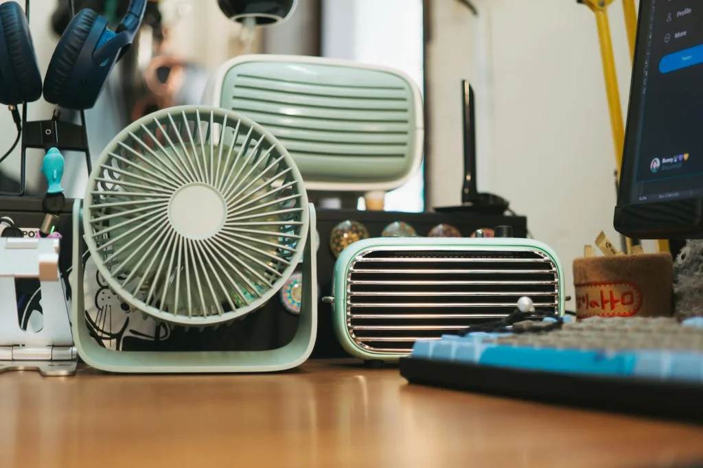 Desk fan on a home office workspace for summer cooling
