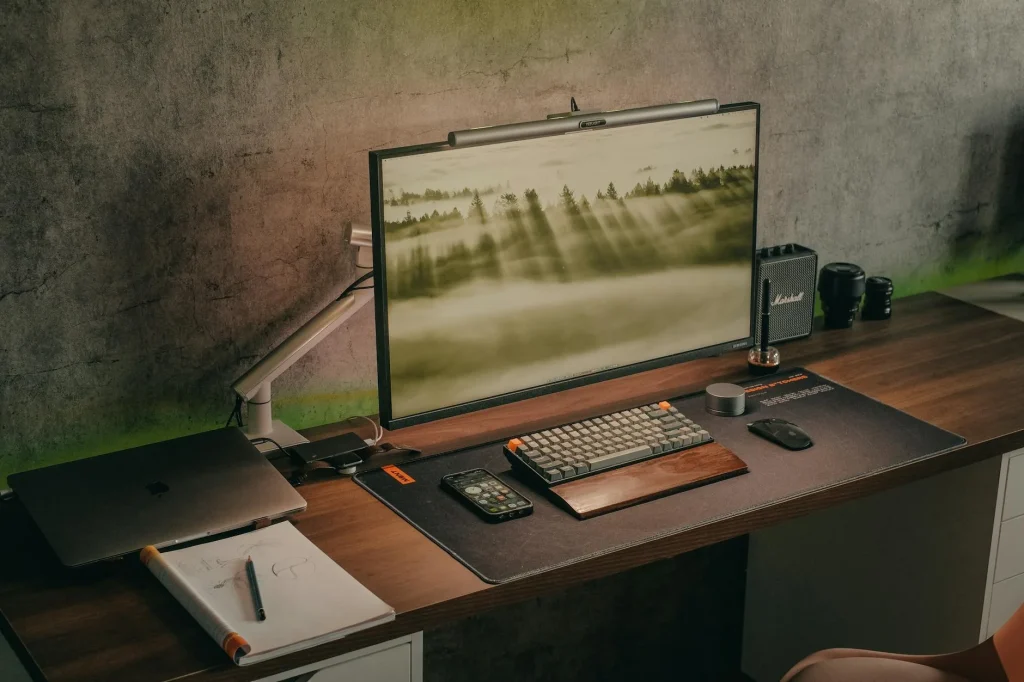 Laptop connected to a docking station with monitor keyboard and mouse on a clean desk