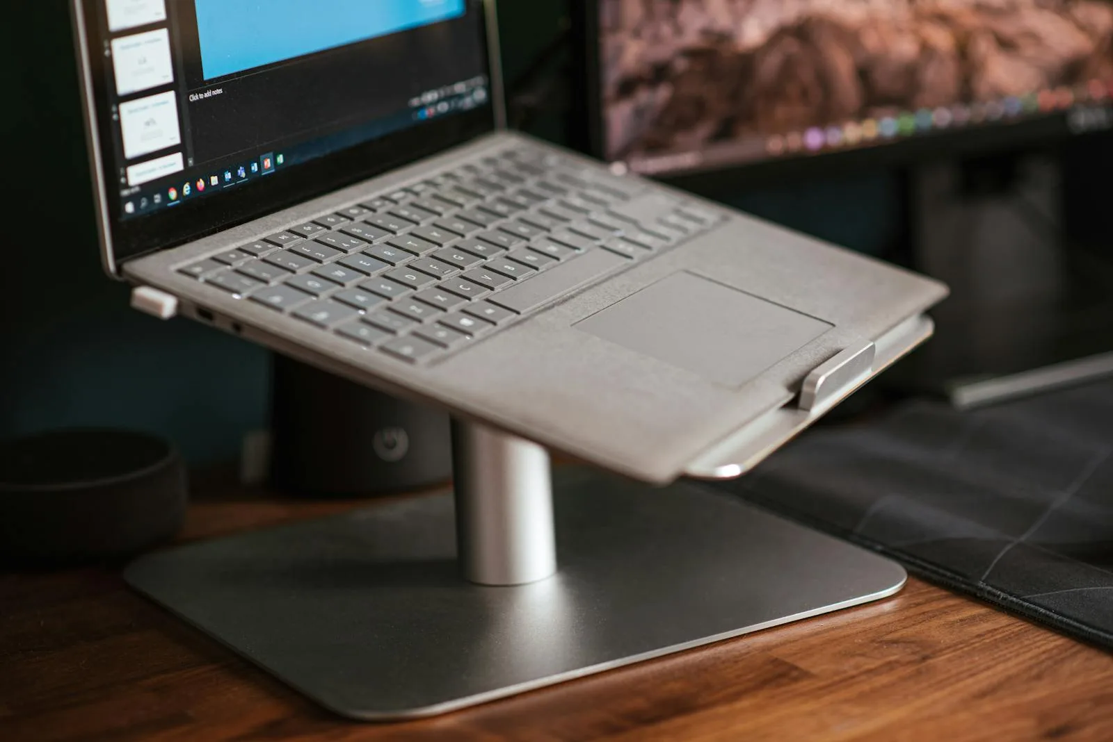 Laptop on an aluminium riser stand with external monitor on a home office desk