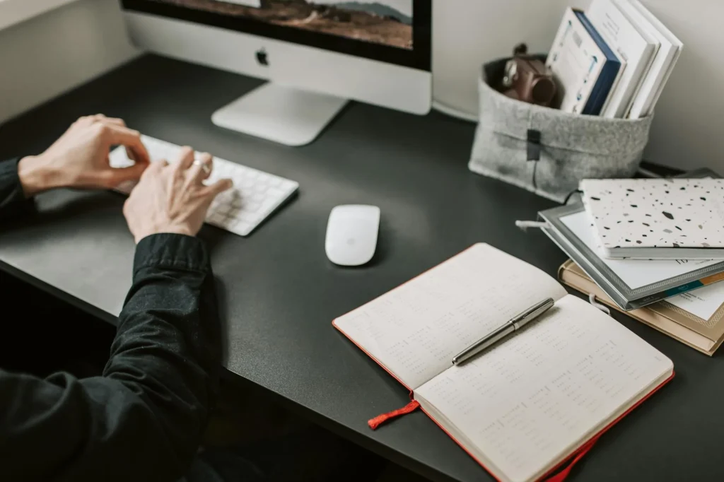 Person sitting at desk with monitor positioned at ergonomic eye level