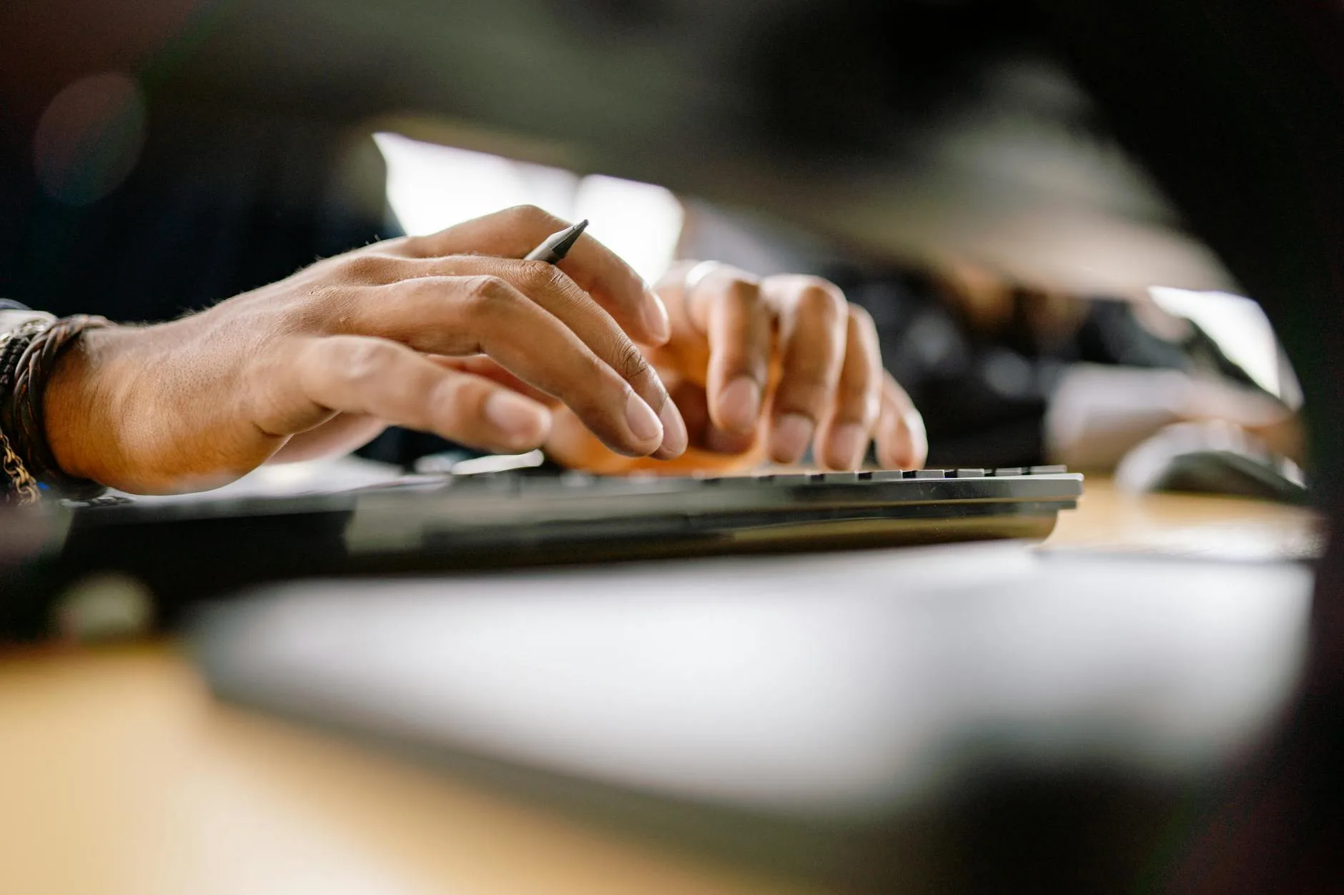 Person typing at a keyboard with correct wrist posture at a desk