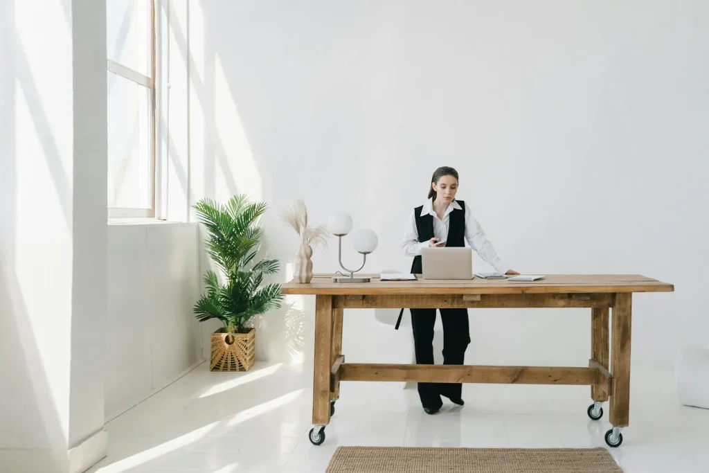 Woman standing while working at a raised desk in a bright home office