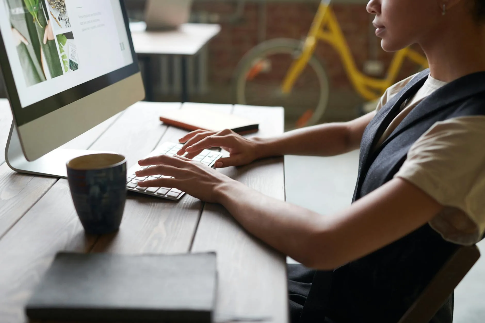 Person sitting upright at a desk with monitor in an office