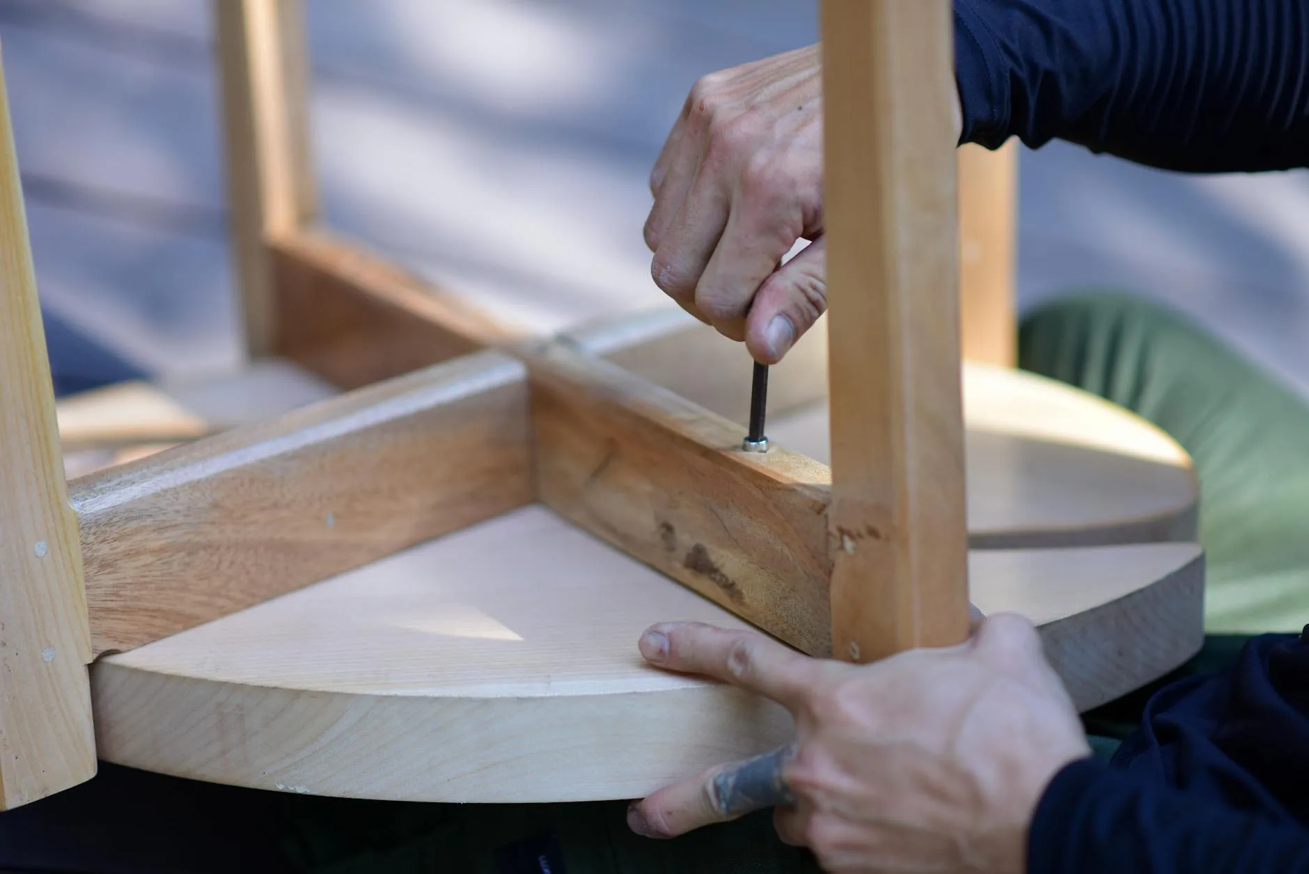 Person tightening desk screws with an Allen key
