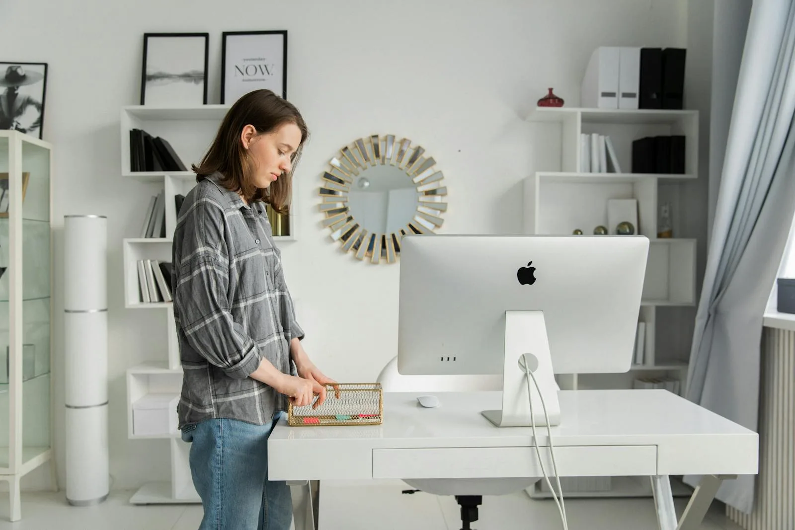 Woman organising her white standing desk in a stylish home office