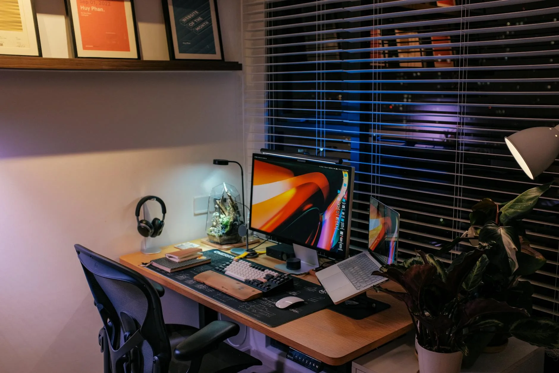 Desk lamp providing task lighting beside monitor