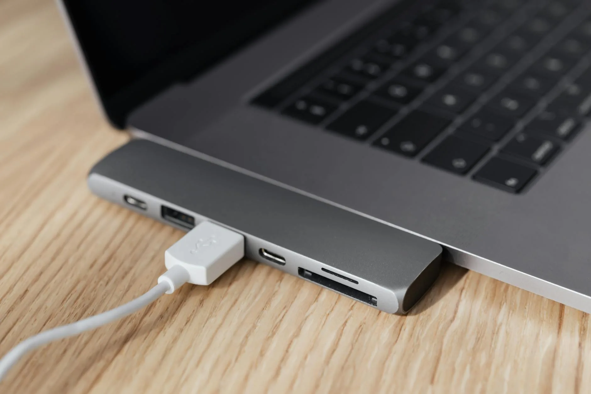 Single USB-C cable connecting laptop to monitor on a tidy desk