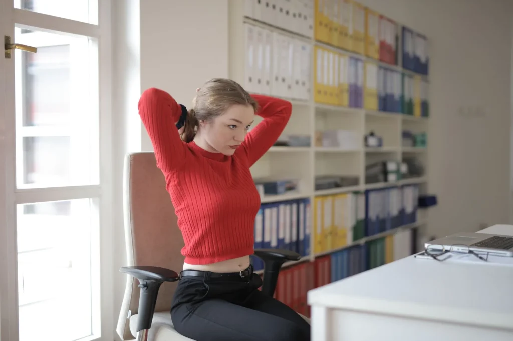 Office worker doing desk stretches to prevent back pain