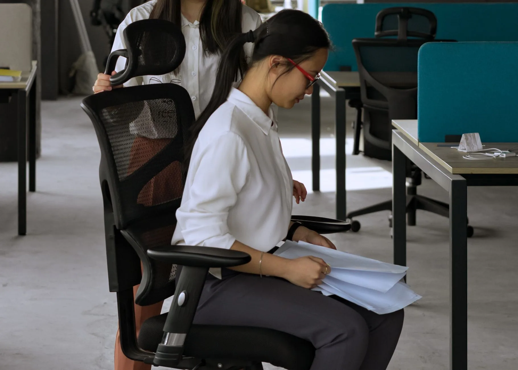 Ergonomic chair backrest being adjusted for better desk posture