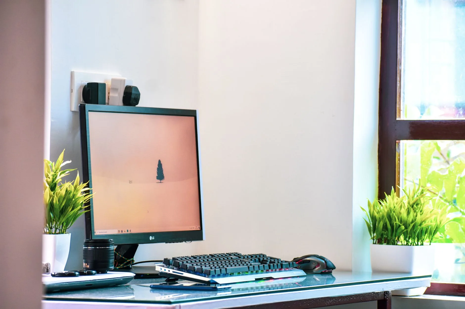 Flat monitor on an office desk with keyboard and laptop