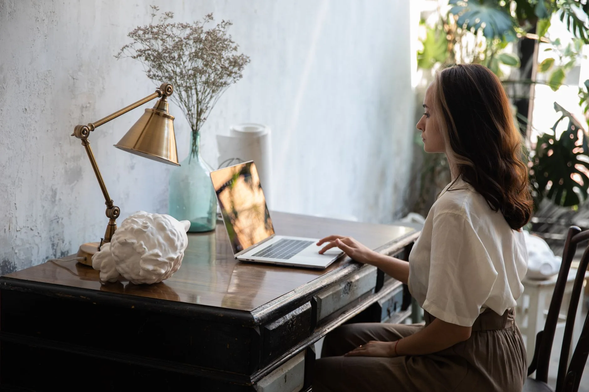 Boho workspace with desk lamp, plants and natural wood finishes