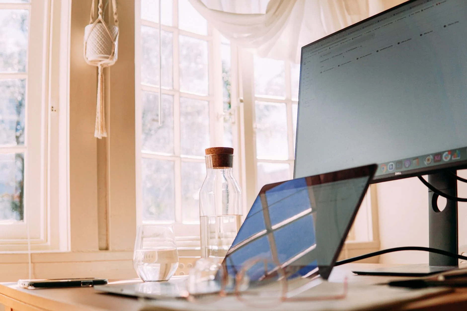 Glass desk with monitor and laptop in a home office setup