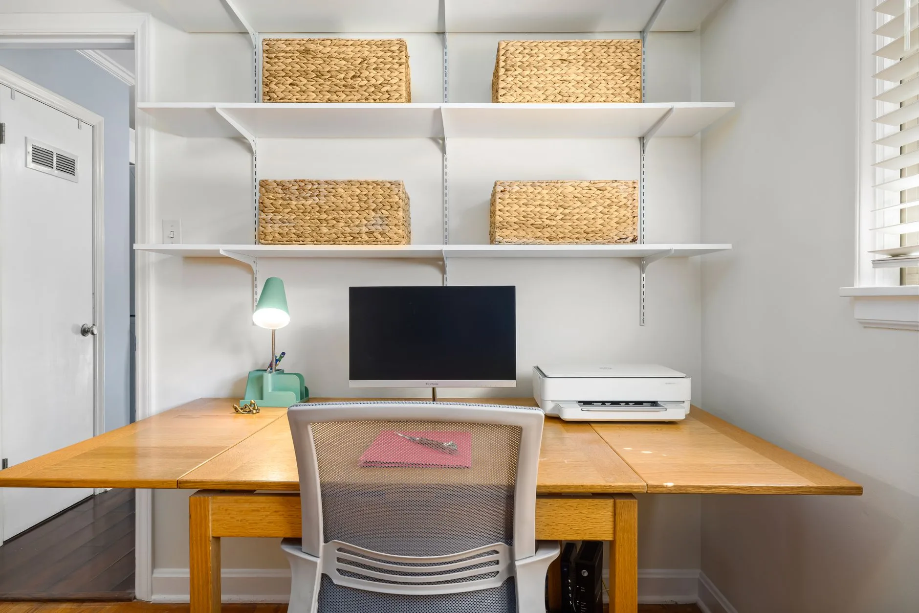 Compact home office desk with storage shelves and a laptop