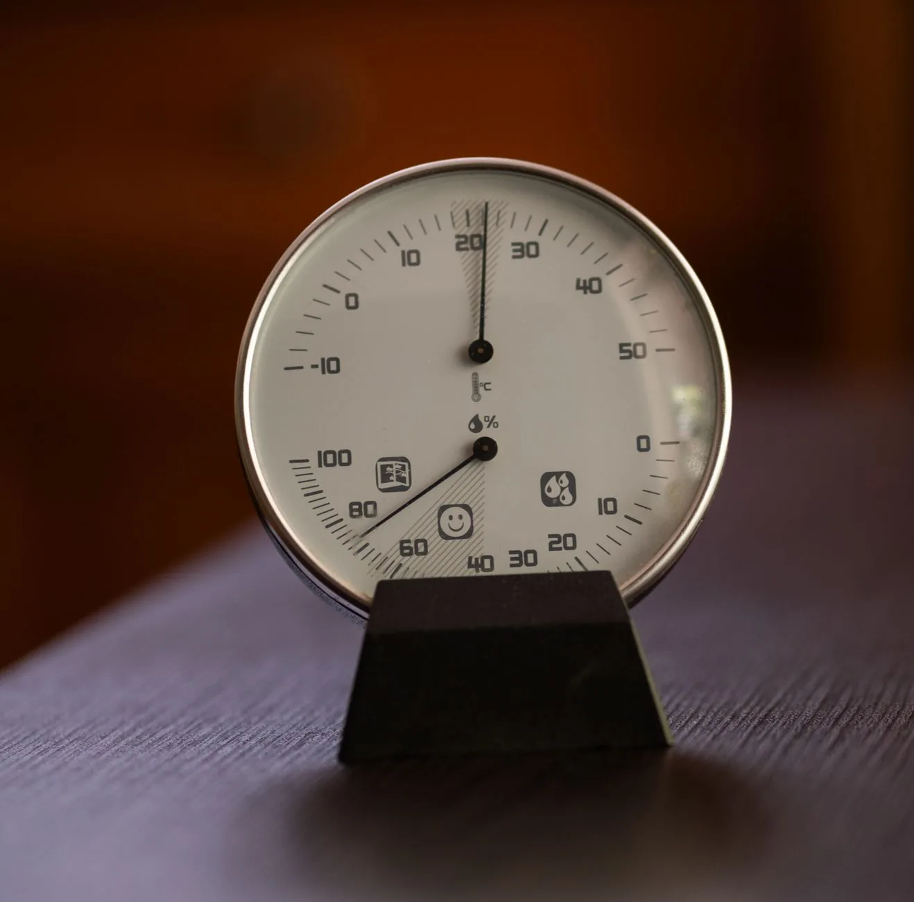 Desk hygrometer showing office humidity beside work equipment