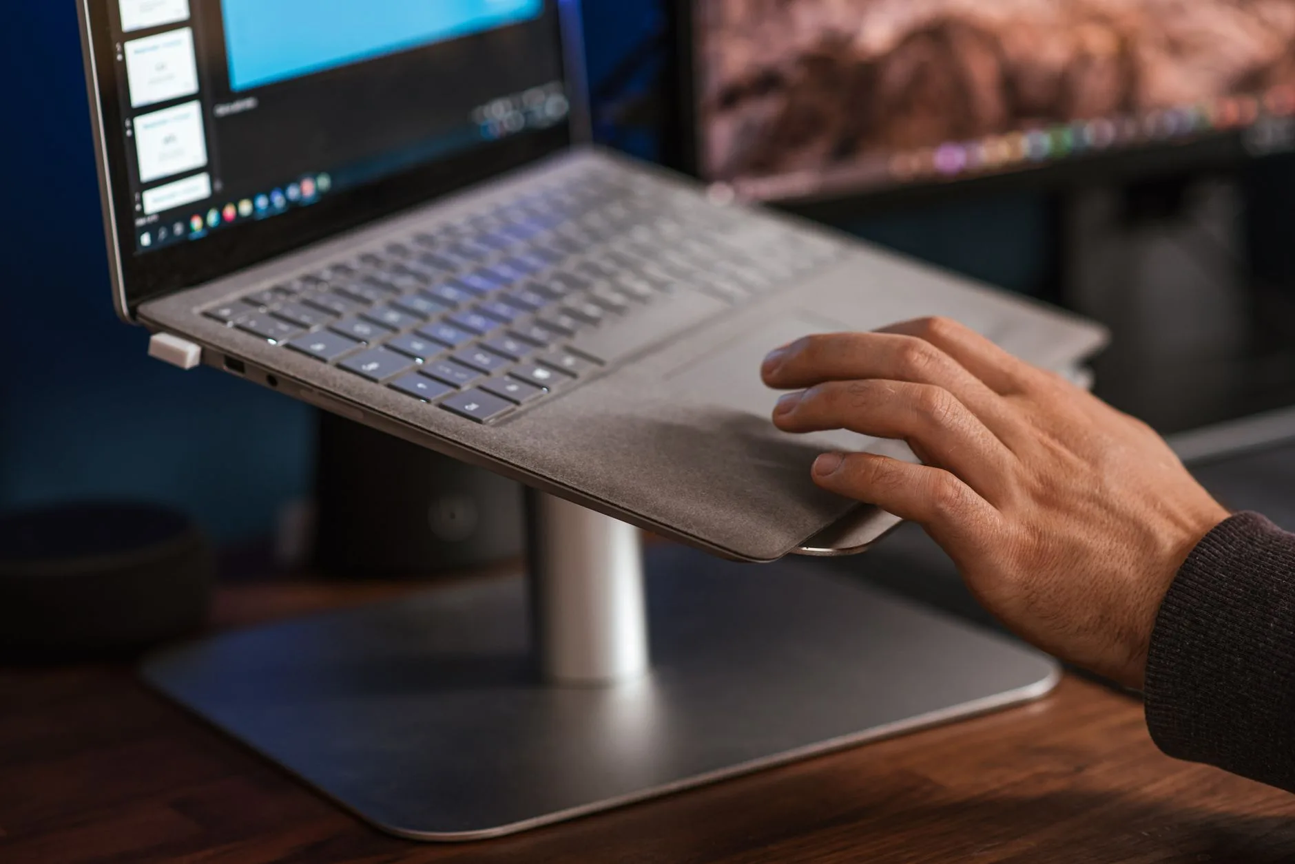 Laptop on a raised stand above an external keyboard